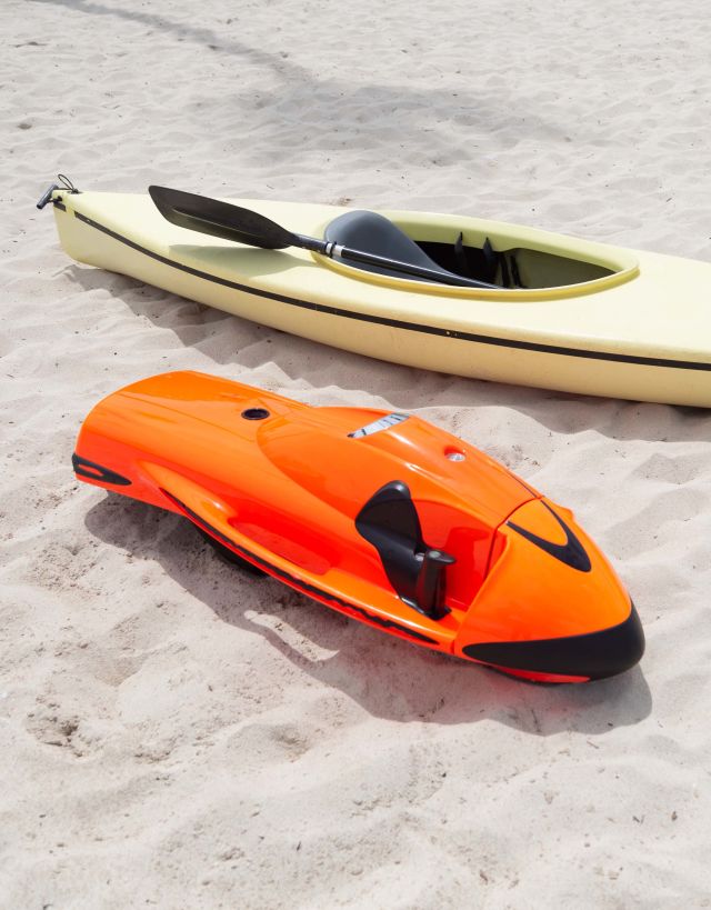 Seabob sitting next to a kayak on the sand