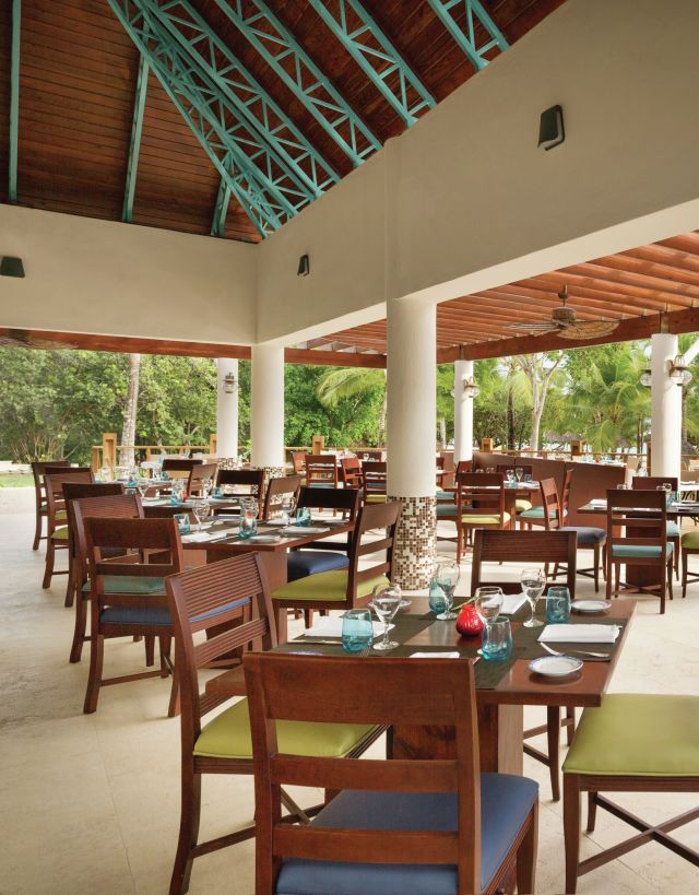 an outdoor covered patio with dining tables