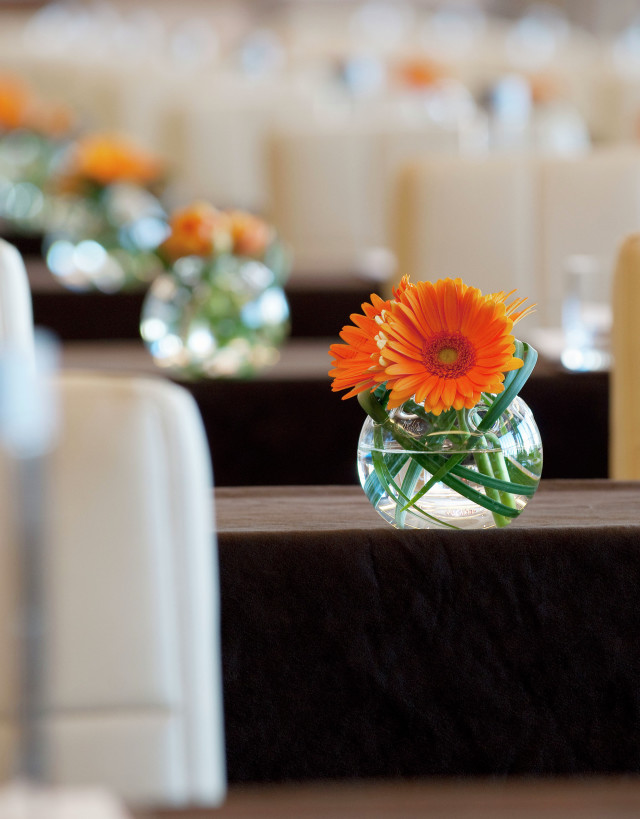 Orange flower in round glass vase in Ballroom 