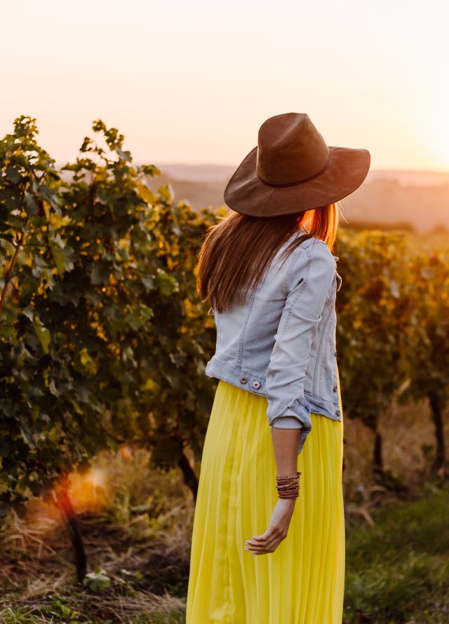 Woman walking along vines in vineyard