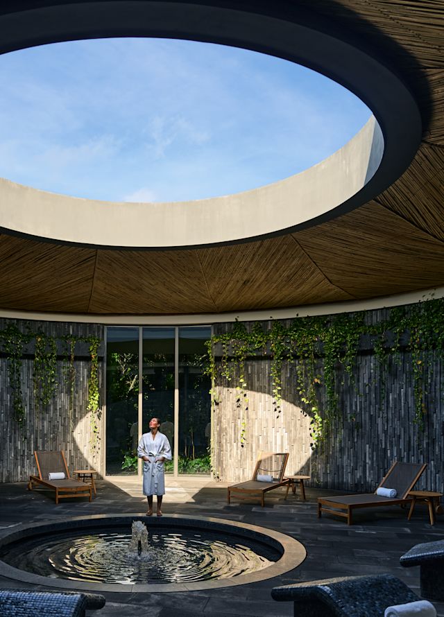 Spa area with beam of light illuminating a circular portion of the wall. A person is standing in the light