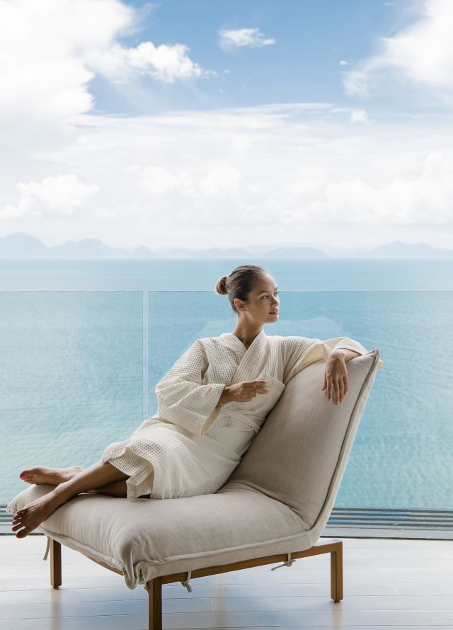 Model sitting on chair overlooking the sea