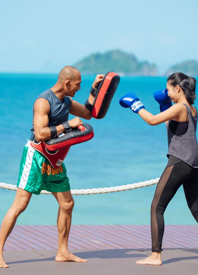 Man and Woman Boxing Outdoors with View of the Beach