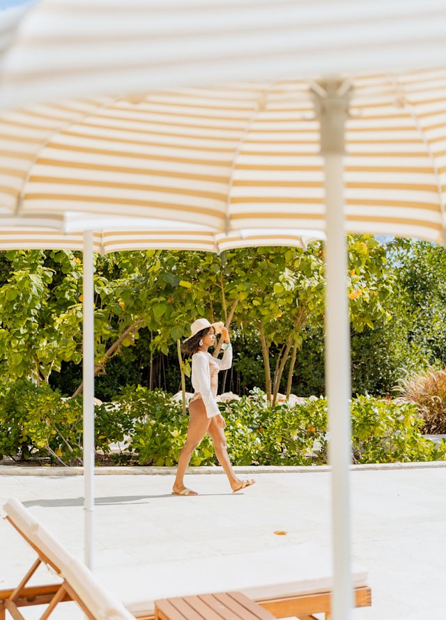 guest walking by the lounge chairs and umbrellas