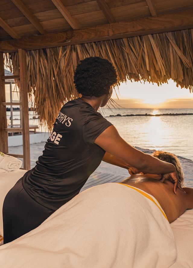 A Woman is Enjoying a Massage on a Cabana at the Beach