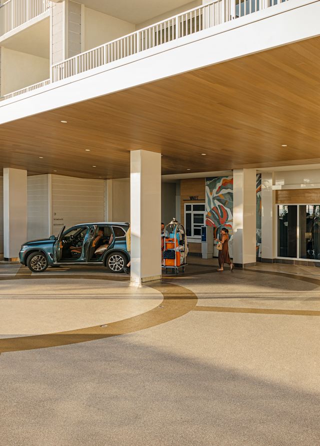 tamu berjalan di luar pintu masuk hotel