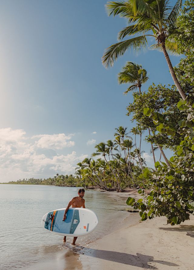 A man carrying a surf board.