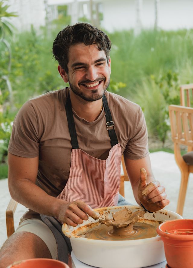 A man shaping clay during a pottery class.