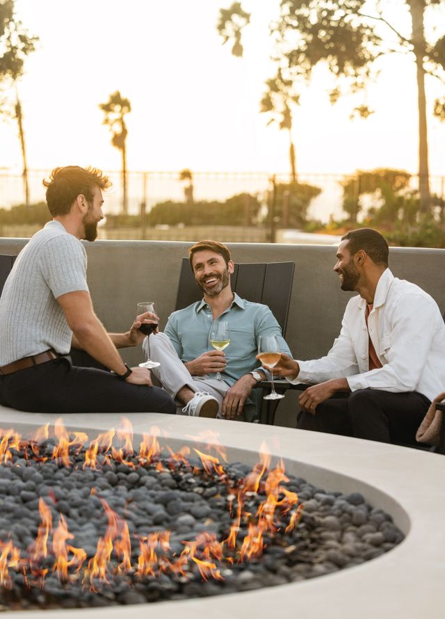 Men Enjoying Drinks in a Patio with a Fire Pit