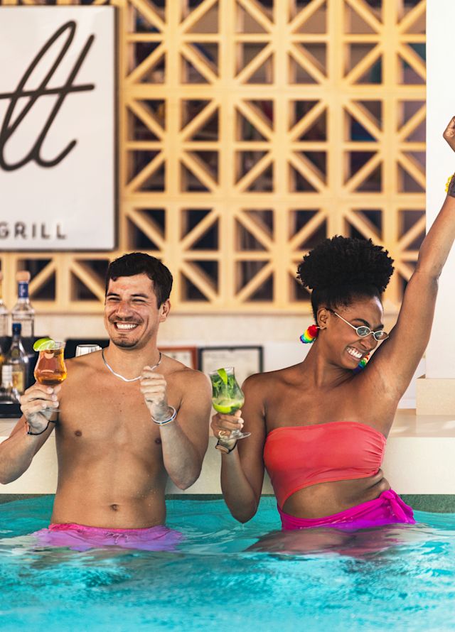 Prieteni bucurându-se de o băutură la piscină, la barul și grătarul din Seasalt