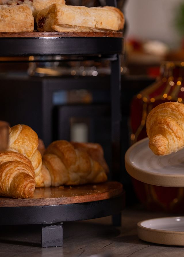 A man selecting pastries and other foods at the breakfast buffet