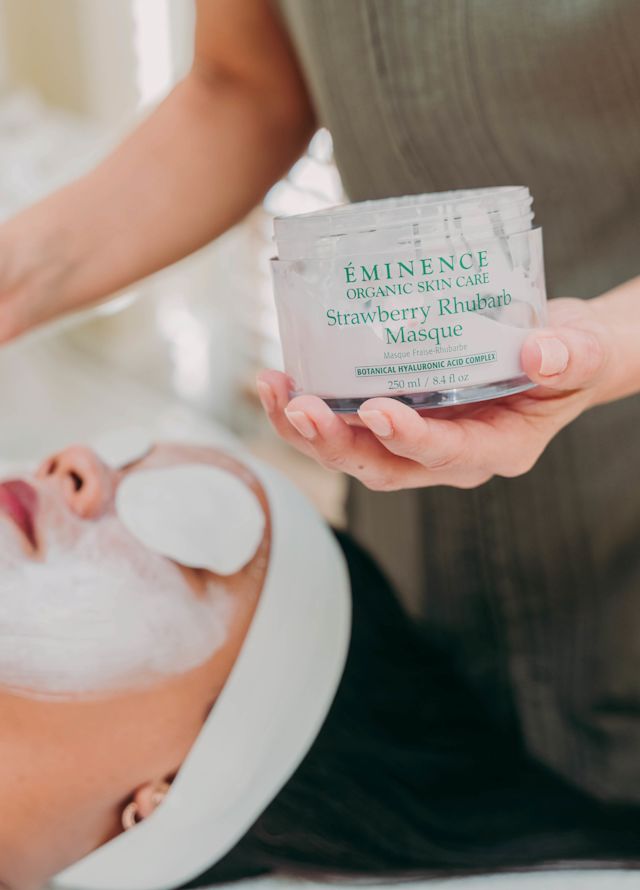 Woman lying on a bed with a face mask getting a facial