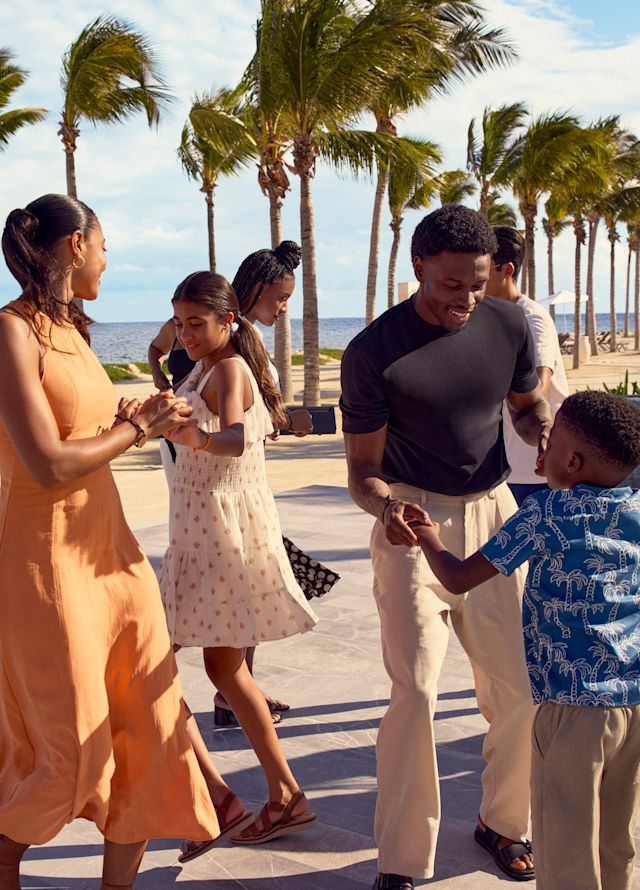 Mother, teenage daughter, father and son are having fun at a dance class on the beach
