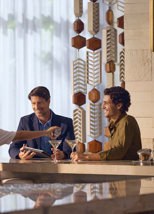 Zwei Männer bestellen Drinks an der Hotelbar