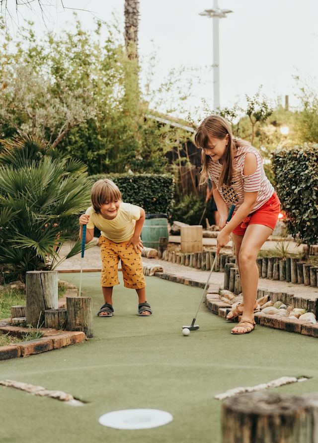 Kids playing mini golf