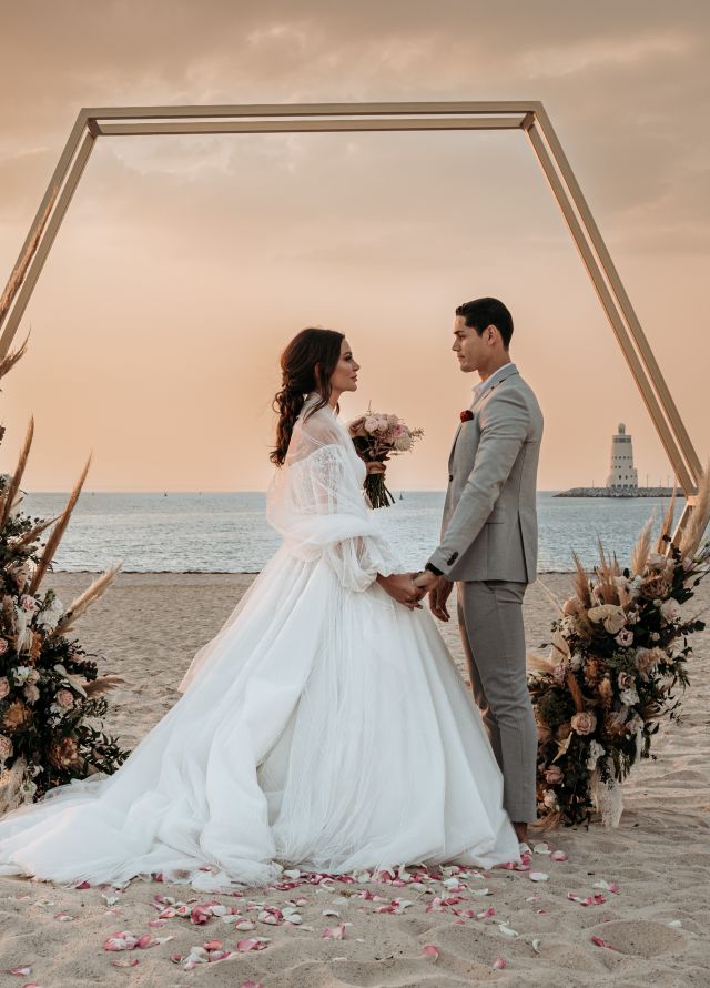 Bride and groom standing on beach