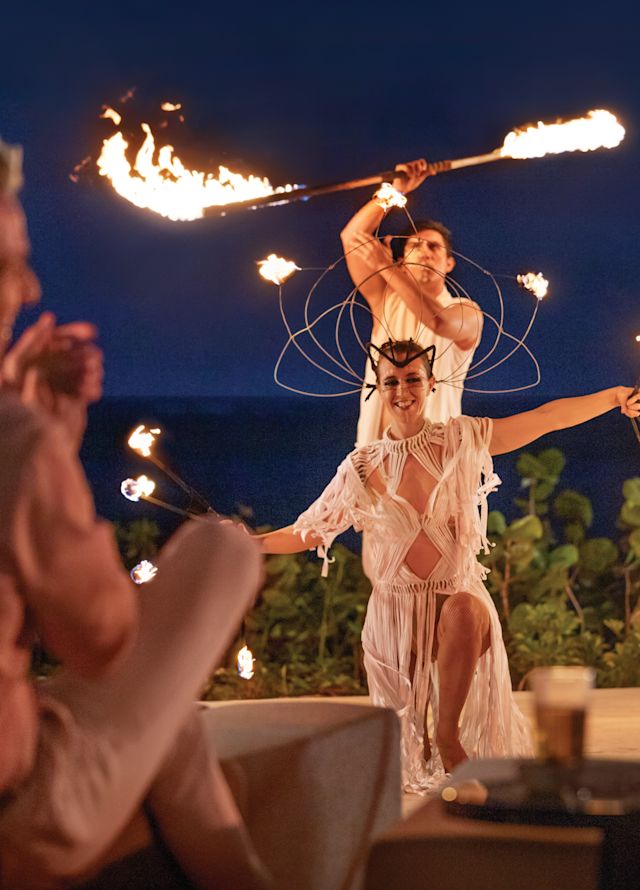 People clap and cheer for fire dancers