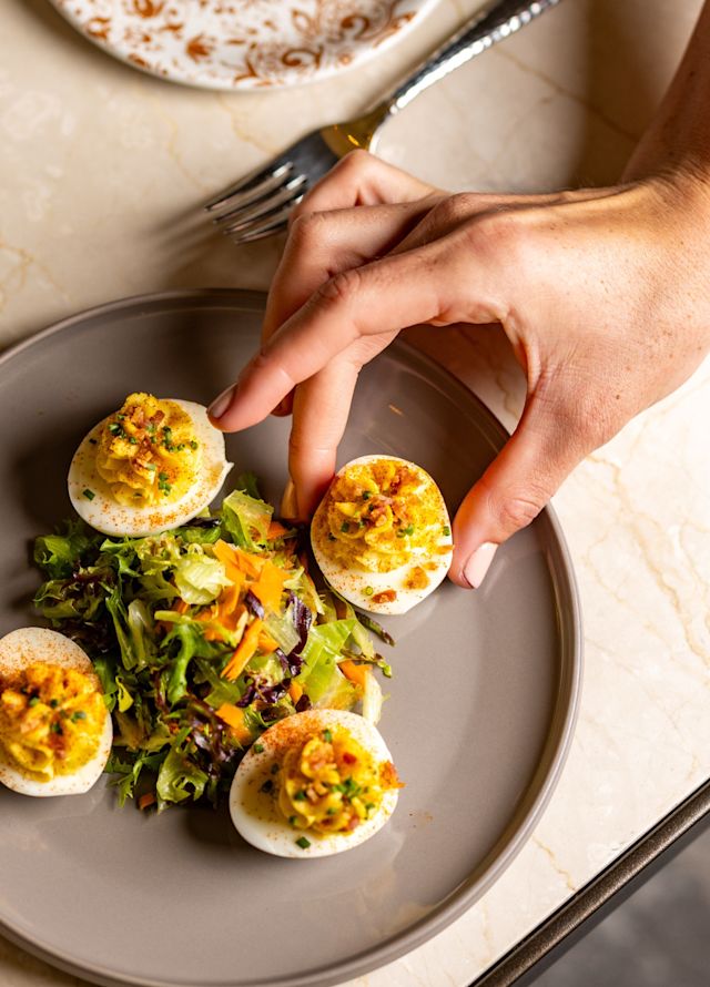 Hand Getting a Deviled Egg from a Salad Plate at Peacock Alley Restaurant