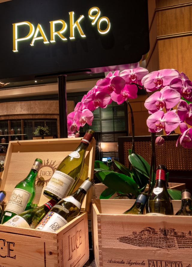 Selection of wines displayed in crates in front of Park90 wine bar sign
