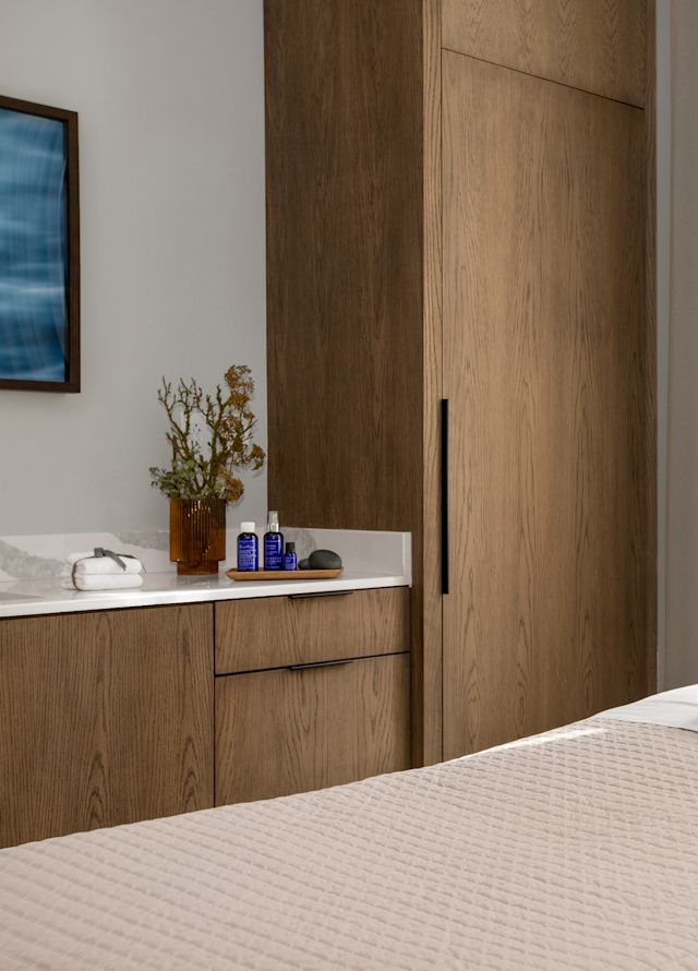 Spa treatment room with a table and cabinets.