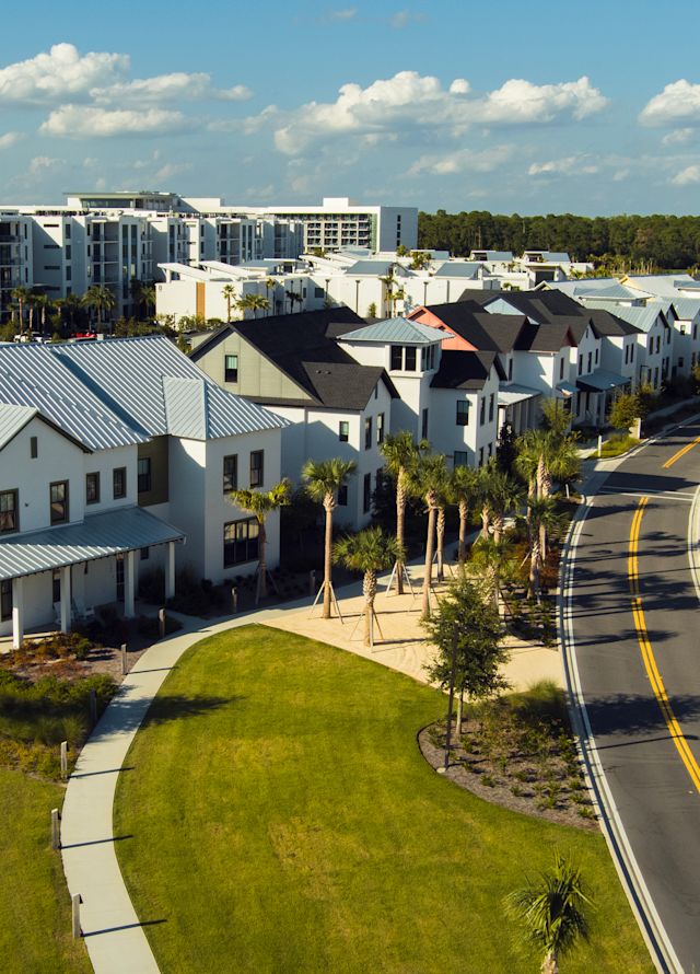 Row of buildings with road curving up between trees
