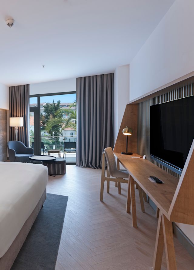 Room with Bed, TV, Work Desk, and Balcony