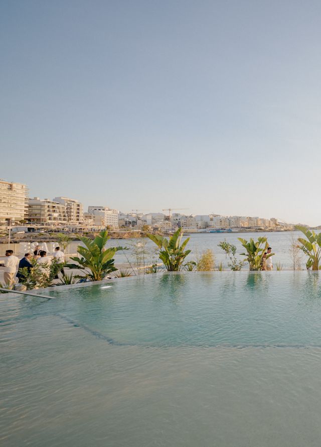 Odkryty basen z leżakami i widokiem na morze