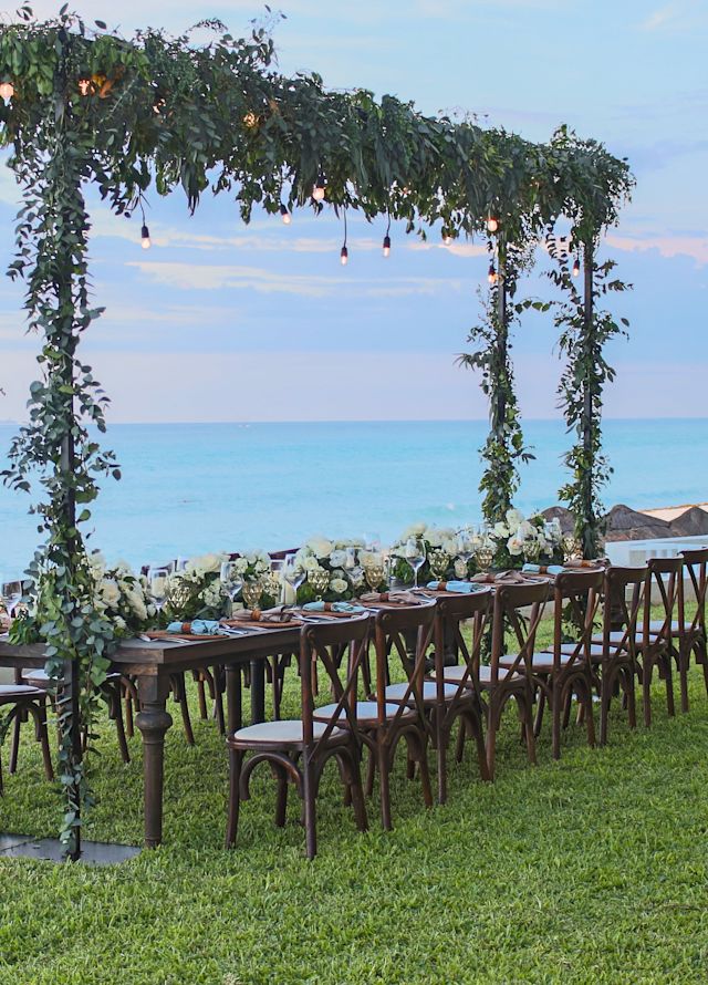 Disposición de mesa para una celebración de boda en un patio con vista al mar