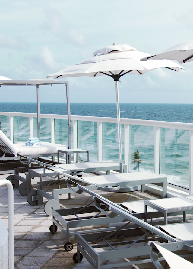 تراس شروق الشمس مع مظلات ومقاعد للتمدد مواجهة للشاطئ