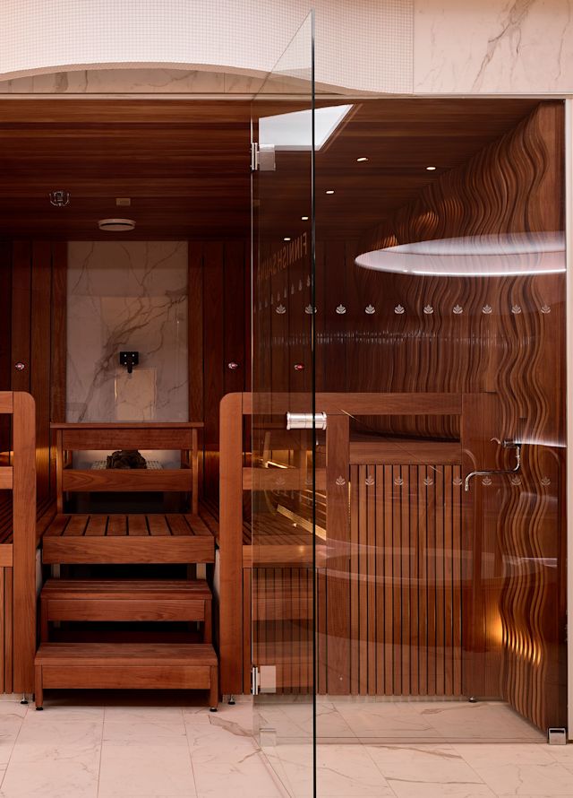 Sauna con paneles de madera y puertas de vidrio