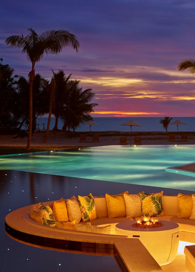 fotografie pe timp de noapte cu piscină, cu ocean în fundal