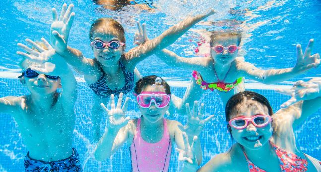 Little kids swimming in pool underwater