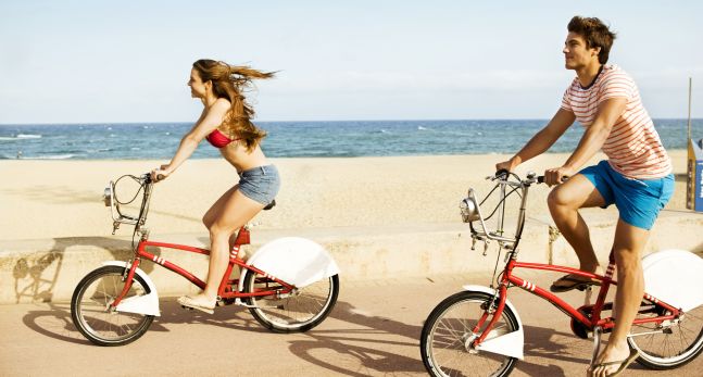 Man and Woman Riding Bikes Along Beach