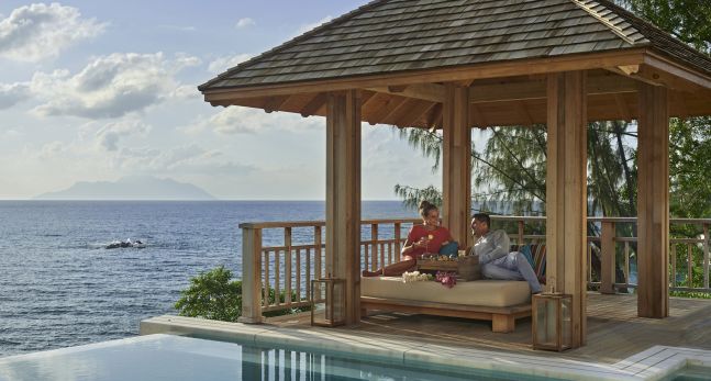 A Couple Lounging in Villa with cocktails