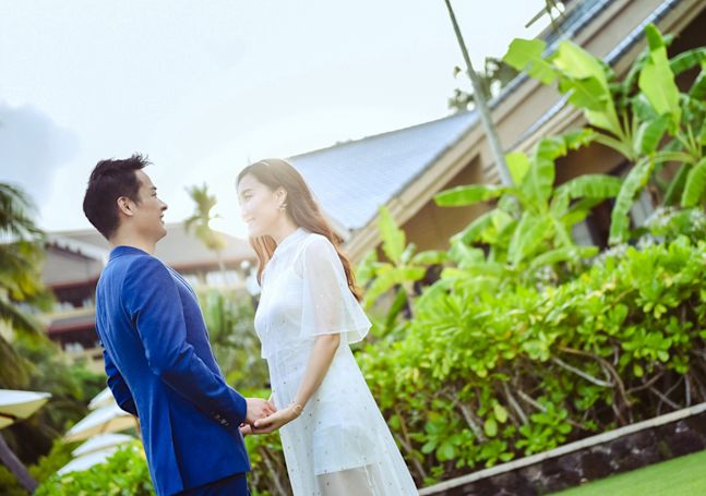 Couple Holding Hands with Greenery in Background