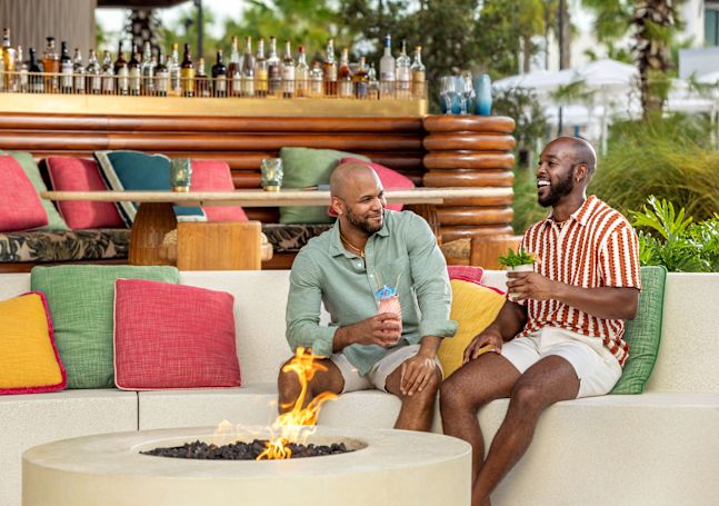 ospiti che sorseggiano un drink accanto al focolare del Papaya Club