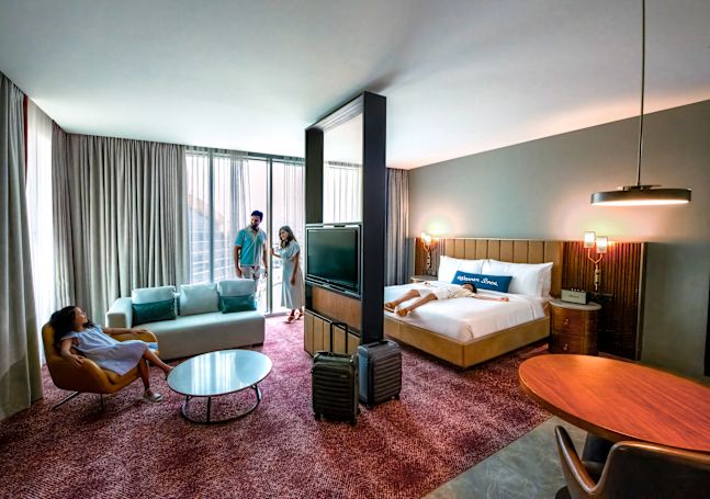 Guest room with bed, lounge area and TV