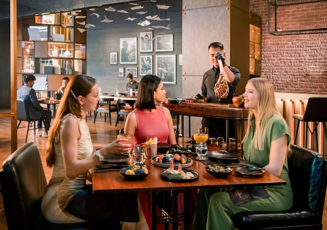 Group of people in restaurant area with food and drink