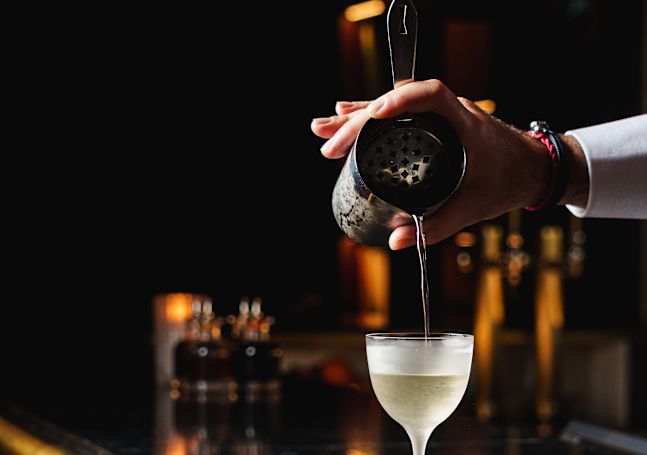 Barman che prepara un drink al Caley Bar