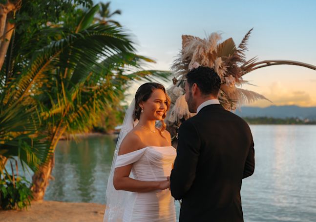 Beach wedding ceremony setup with arch and arranged seating