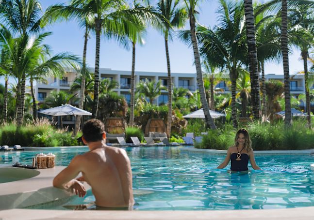 Swim-up bar with submerged stools at the pool edge