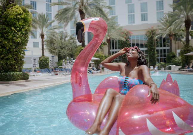 a Woman Sitting on an Inflatable Toy at the Pool