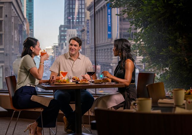 People dining at Cable 55 restaurant with city view