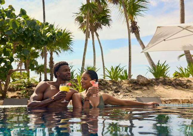 Man and woman relaxing in the pool with drinks