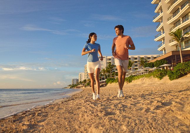Мужчина и женщина бегают на пляже отеля