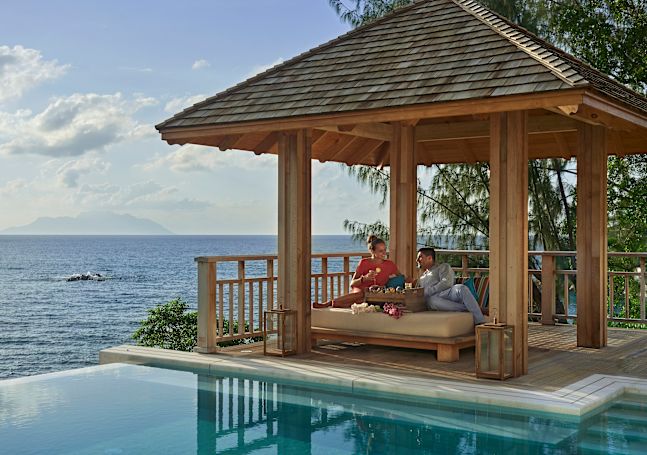 A Couple Lounging in Villa with cocktails