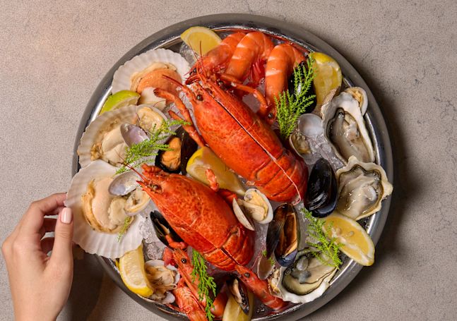 A Woman Dining a Seafood Platter at Estate Restaurant