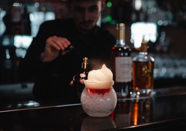 Bartender Adding Mist to a Drink at Skyline Rooftop Bar