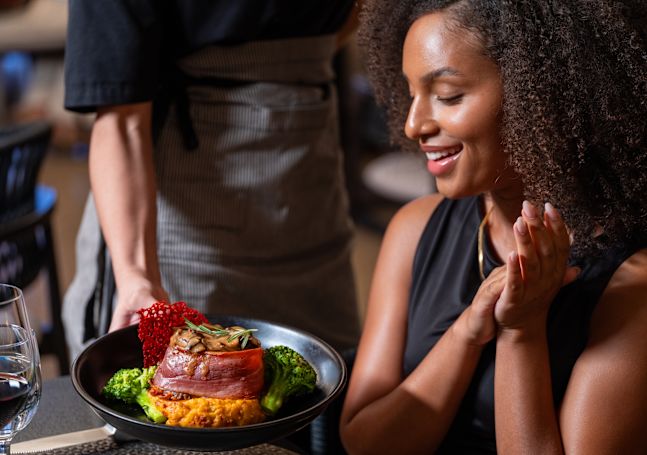 Woman Being Served Dinner at La Cava Restaurant