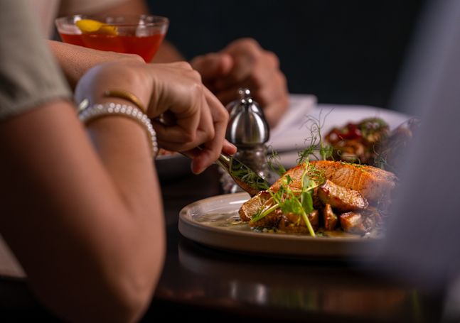 A woman enjoying salmon for dinner